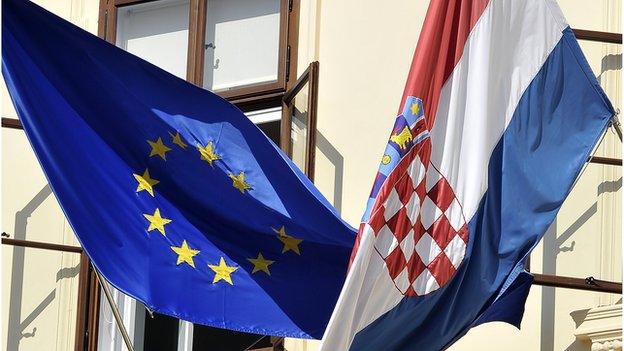 Croatian and European Union flags hang from a government building in Zagreb