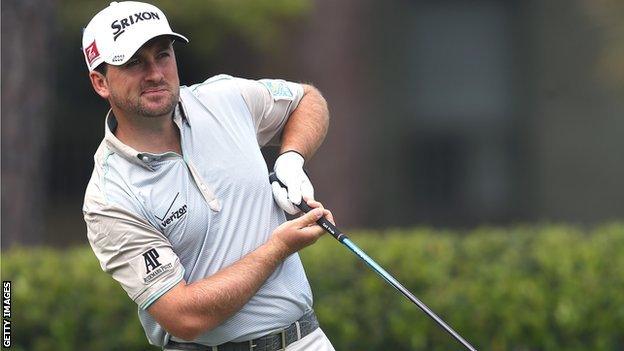 Graeme McDowell reacts to his tee shot on the first hole in the final round