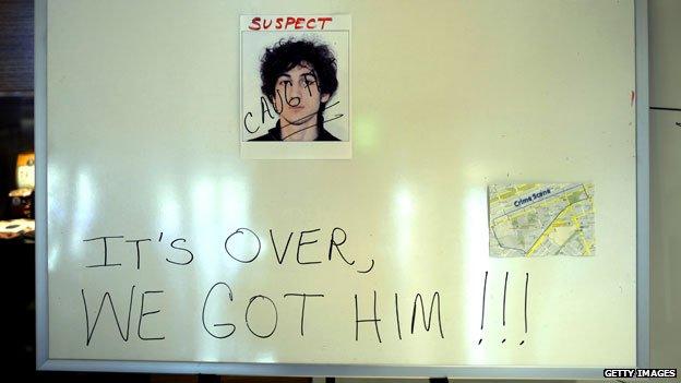 Sign in hotel lobby with photo of Dzhokhar Tsarnaev with caption "It's over, we got him"