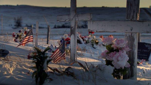 Cemetery decorated with flags, flowers and crosses