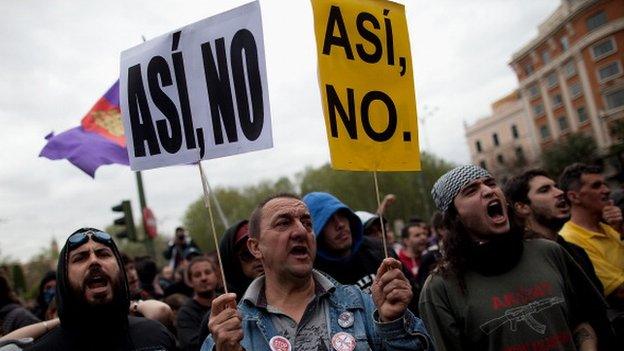 Spanish protestors with signs reading "not this way"