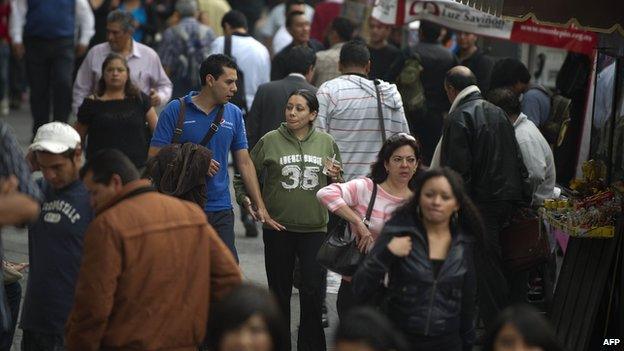 People walk on a crowded street in Mexico city