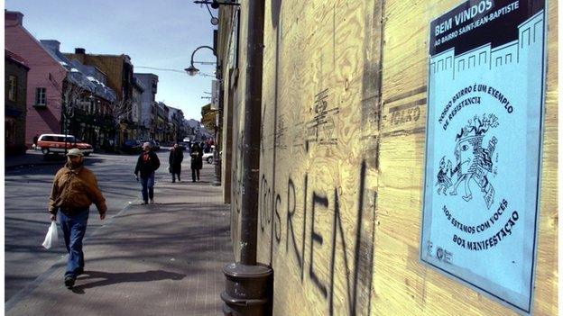 Person walking past a sign in Quebec City