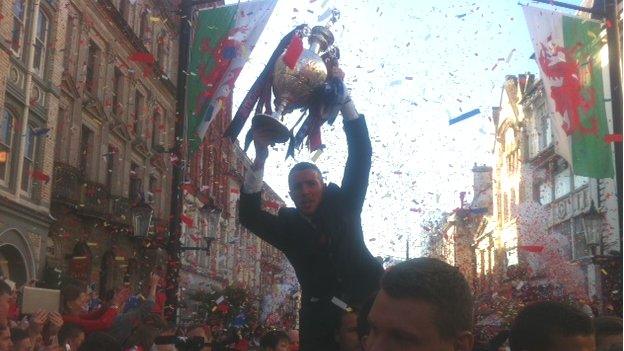 Craig Bellamy is carried shoulder high down High Street carrying the cup