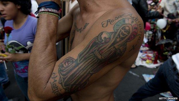 A man with a tattoo of Santa Muerte attends a procession on 1 November 2012