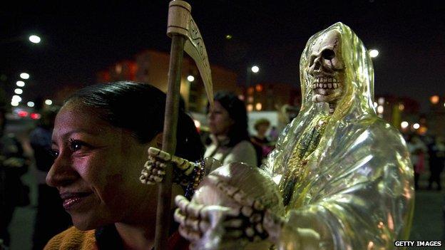 A woman holds a statue of Santa Muerte at a procession in Mexico City on 1 November 2012