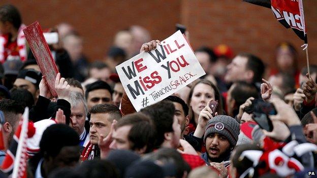 Fan holds placard in crowd at Old Trafford