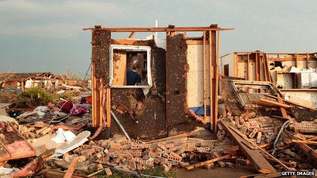 Dana Ulepich searches inside a room left standing at the back of her house