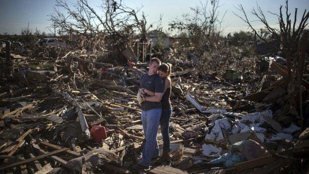 Danielle Stephan holds boyfriend Thomas Layton as they pause between salvaging through the remains of a family member's home after the Oklahoma tornado, 22 May 2013