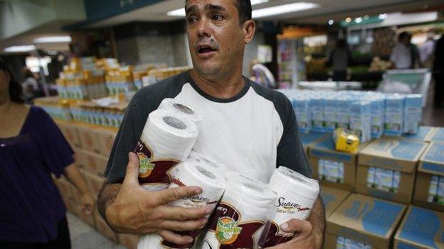 Man carrying several packets of toilet roll