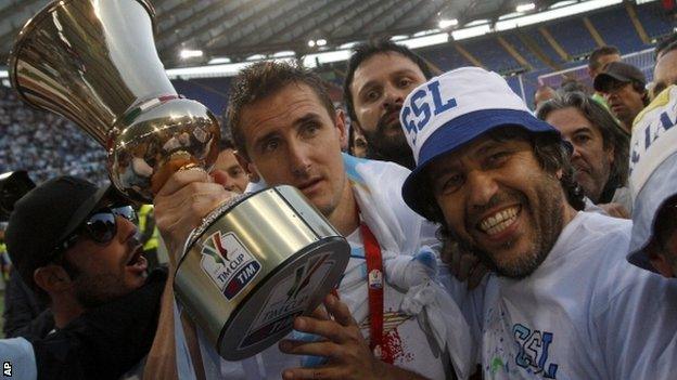 Lazio striker Miroslav Klose shows the Italian Cup to fans after his side's victory over Roma