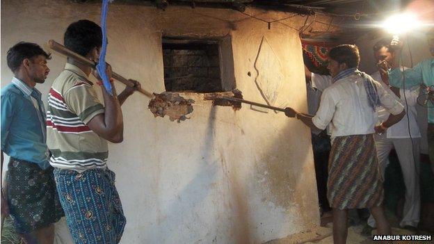 Officials use sticks to break into the room where Keshava had been confined for more than a decade