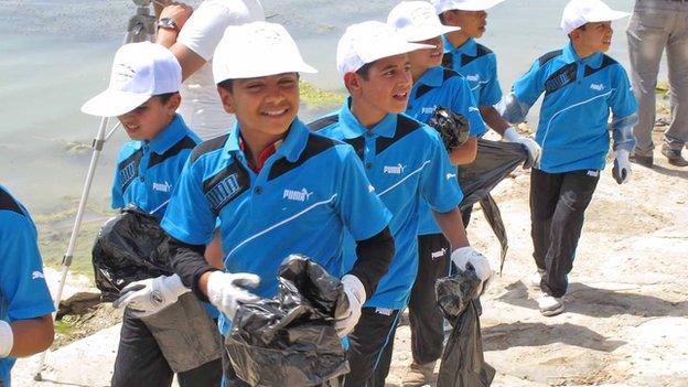 Children carrying plastic bags to pick up litter