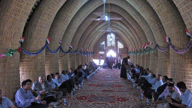 Men sit in the mudheif