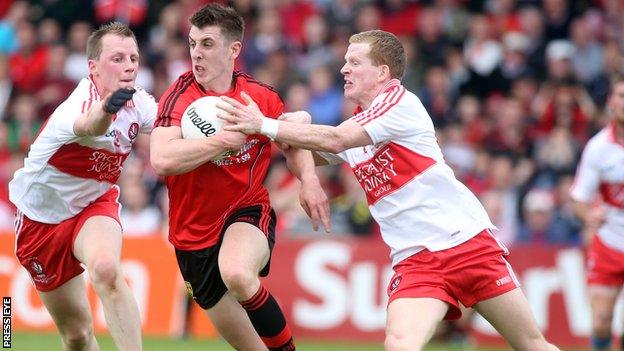 Down's Ryan Boyle in possession against Enda Lynn and Brian McCallion of Derry