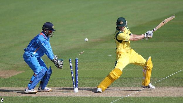 Australia batsman Adam Voges (right) is bowled as India's MS Dhoni looks on