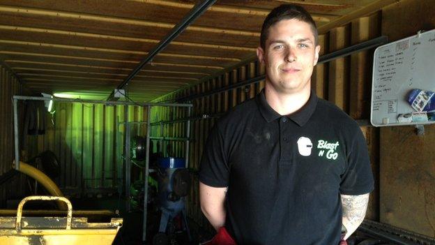 Danny Burnside stands in the container he uses as a workshop