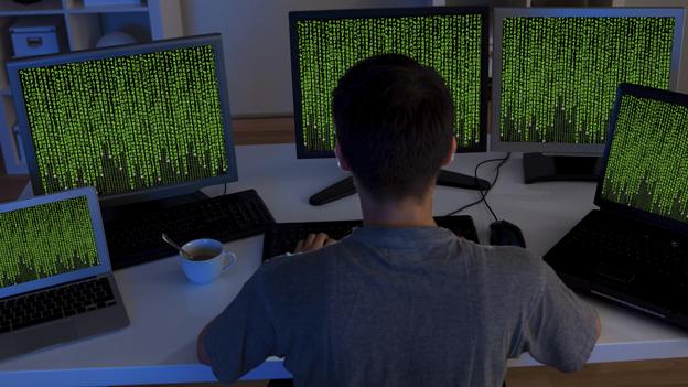 Man in front of computer screens - posed photo