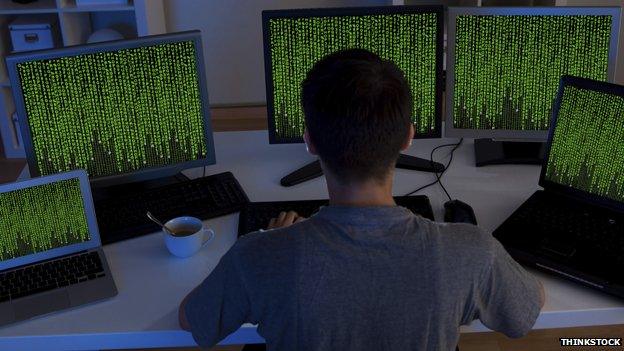 Man in front of computer screens - posed photo