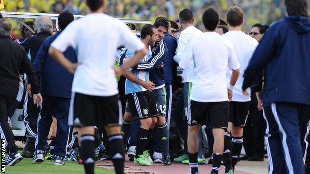 Javier Mascherano is held back by Argentina staff