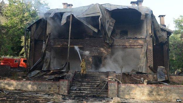 A Pakistani firefighter extinguishes a fire which gutted a historical building in Ziarat, south-east of Quetta, 15 June