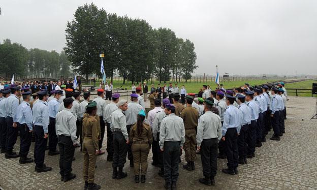 Soldiers stand to attention around the Israeli flag