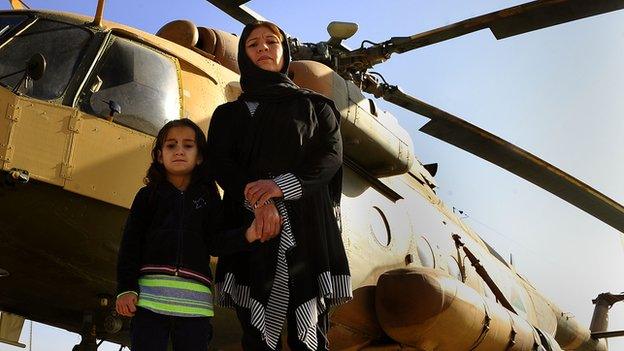 Latifa and Malalai Nabizada standing in front of a helicopter