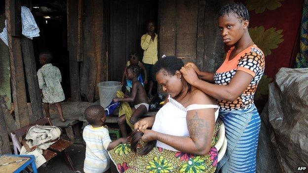 A woman gets her hair done in a shanty town in Lagos, Nigeria (30 August 2012)