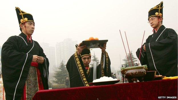 People dressed in traditional costumes of Han nationality, offer fruits as scarifices to Heaven