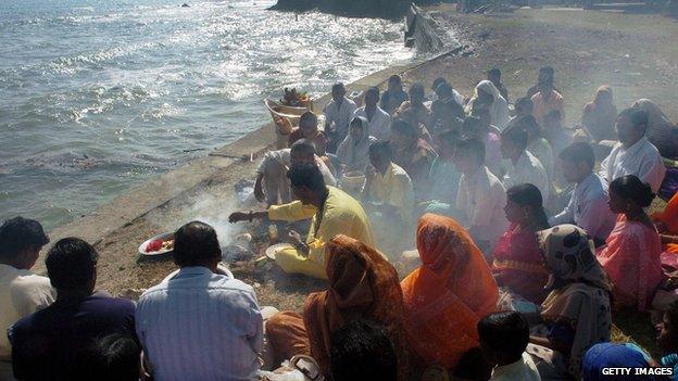 Hindu devotees worship the sun god by the sea