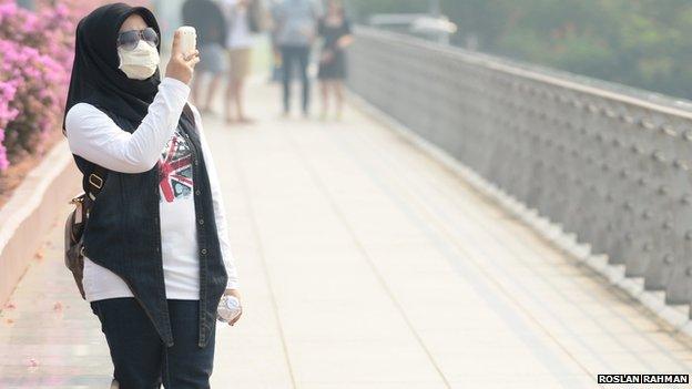 Woman wearing a smog mask in Singapore