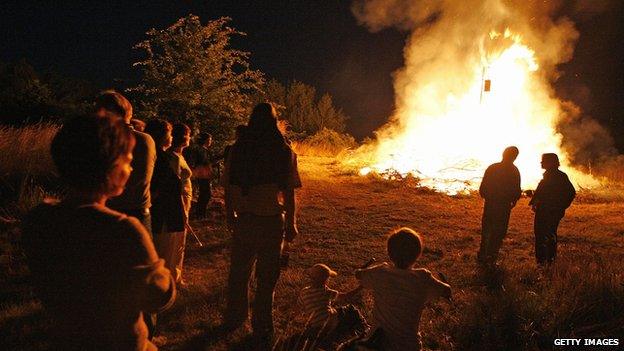 People watch a traditional midsummer festival bonfire to mark the summer solstice