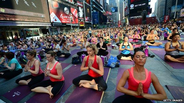 Numerous people practicing yoga in Times Square, New York City