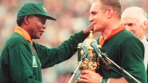 Springbok Captain Francois Pienaar (R) receives the Rugby World Cup from President Nelson Mandela at Ellis Park in Johannesburg on 24 June 1995.