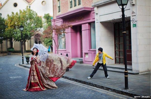 A woman dressed in a red dress walking in Thames Town, China