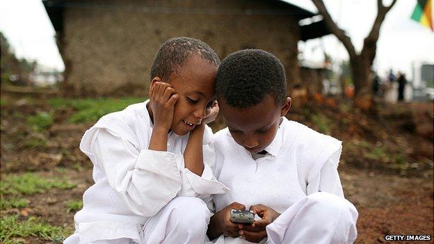 Ethiopian children play with a mobile phone