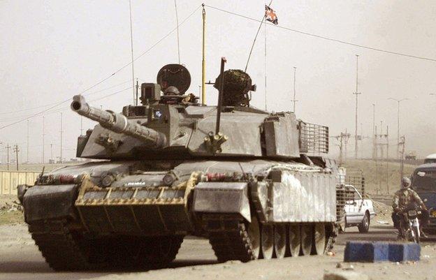 A British Challenger 2 tank driving down a road into Basra, Iraq, in 2006