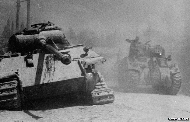 July 1944 - An allied Sherman tank passing a knocked out German Panther tank during the advance on Arezzo, Italy