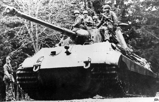 The German Tiger II tank with soldiers sitting on the top