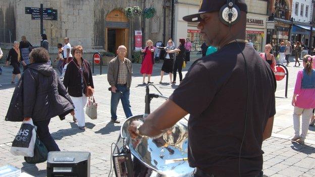 Jamma, from Birmingham, busking with a steel pan in Gloucester