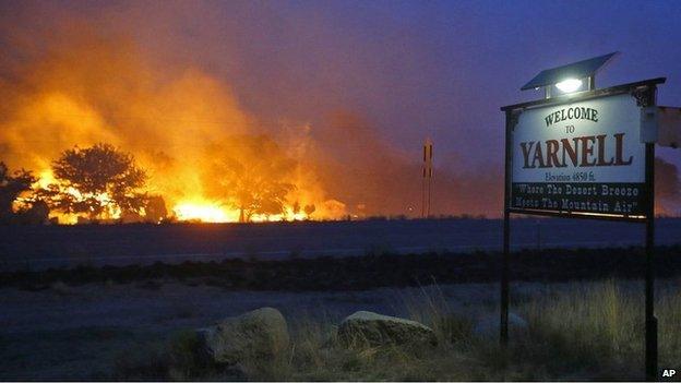 Wildfire burns next to the welcome sign of Yarnell (30 June 2013)