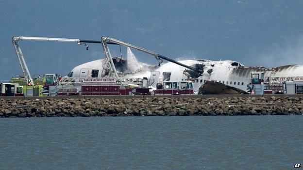 A fire engine sprays water on Asiana Flight 214 after it crashed at San Francisco International Airport on 6 July 2013