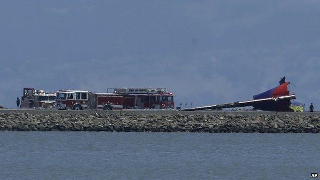 The tail of Asiana Flight 214 is seen, right, after it crashed at San Francisco International Airport in San Francisco, 6 July 2013