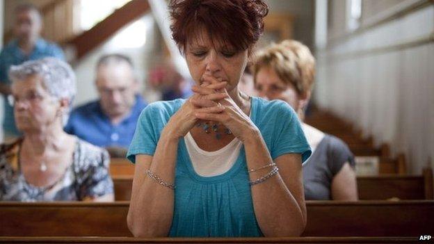 People attend a Mass dedicated to the victims of the train disaster at a church near Lac-Megantic, Canada, 7 July 2013