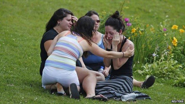 A woman comforts her friend outside the Polyvalente Montignac, the school sheltering people who were forced to leave their homes after the explosion, in Lac-Megantic, 7 July 2013