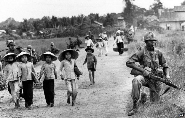 US soldier guards Route 7 as Vietnamese women and school children return home