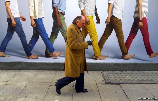 Man walking past advertisement