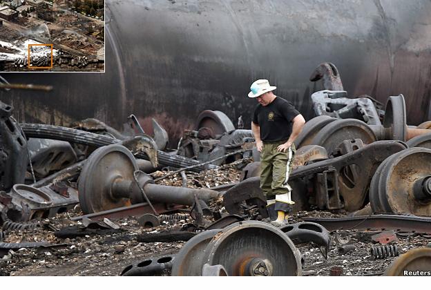 A man inspects the burned remains of the derailed train