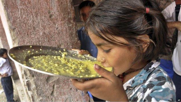 An Indian girl eats her free school lunch at a government run school in Patna on 17 July 2013