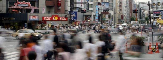 Pedestrians crossing busy street in Tokyo